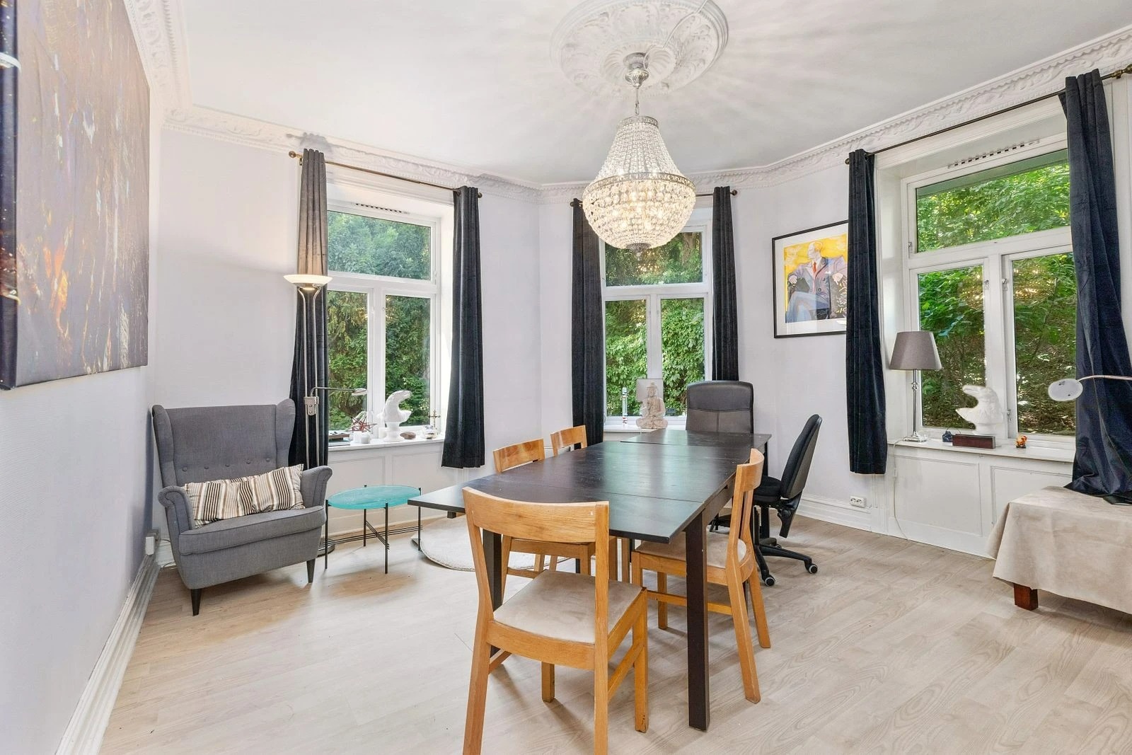 Stue med stukkatur og store vinduer som gir mye lys